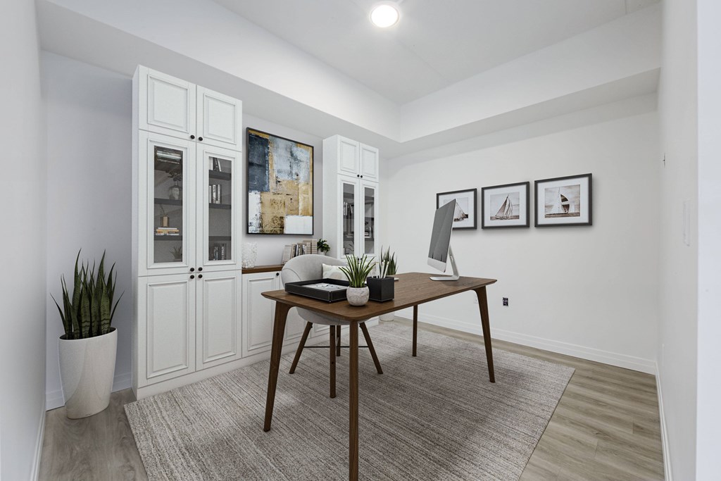 A room with a table, chairs, and a potted plant.