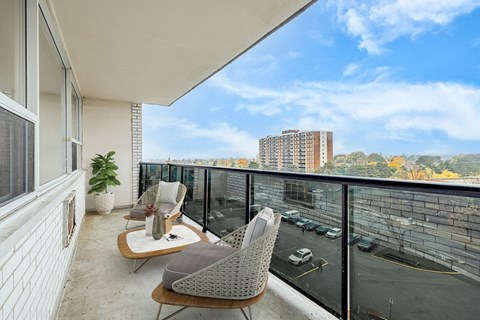 A balcony with two chairs and a table.