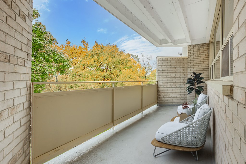 A balcony with a chair and a plant.