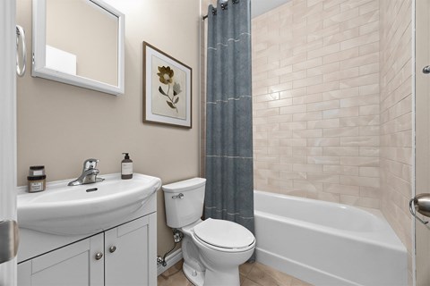 A white toilet sits next to a white sink in a bathroom.