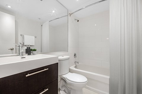 A white bathroom with a toilet, sink, and bathtub.