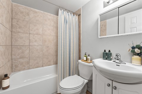 A bathroom with a toilet, sink, and bathtub.