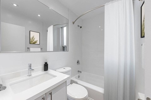 A white bathroom with a sink, toilet, and bathtub.
