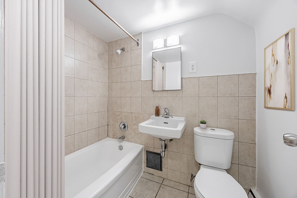 A white toilet sits next to a sink in a bathroom.