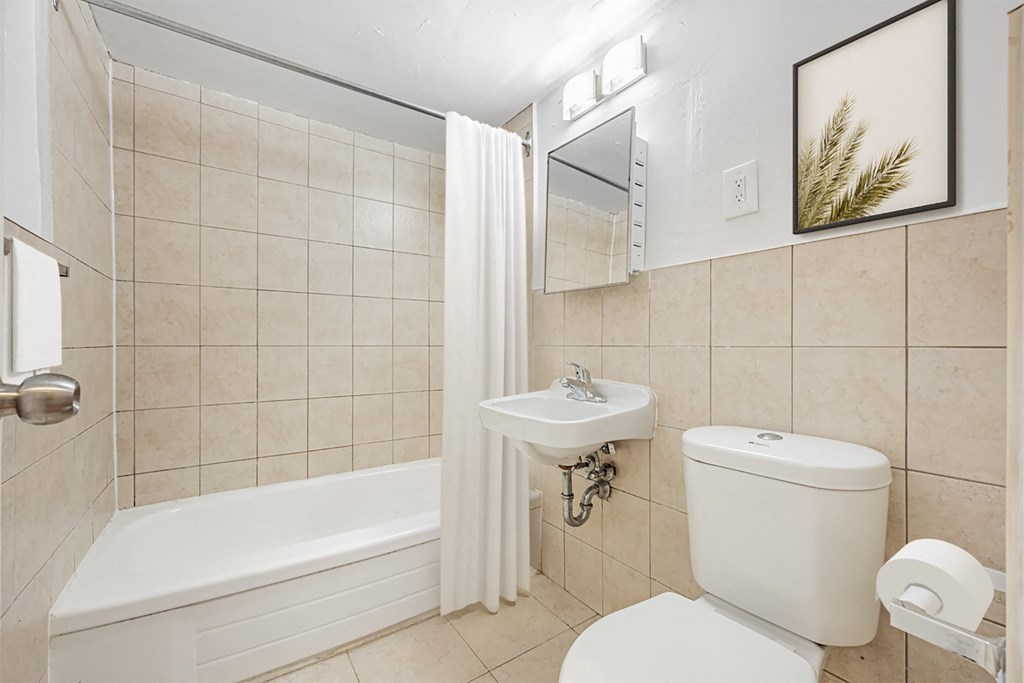 A white bathroom with a toilet, sink, and bathtub.