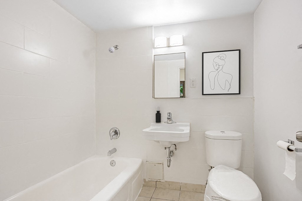 A white bathroom with a tub, toilet, and sink.