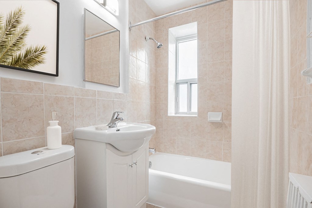 A white bathroom with a sink, toilet, and bathtub.