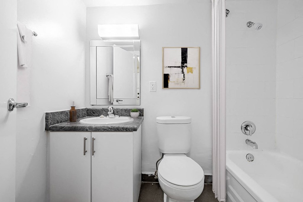 A bathroom with a toilet, sink, and bathtub.