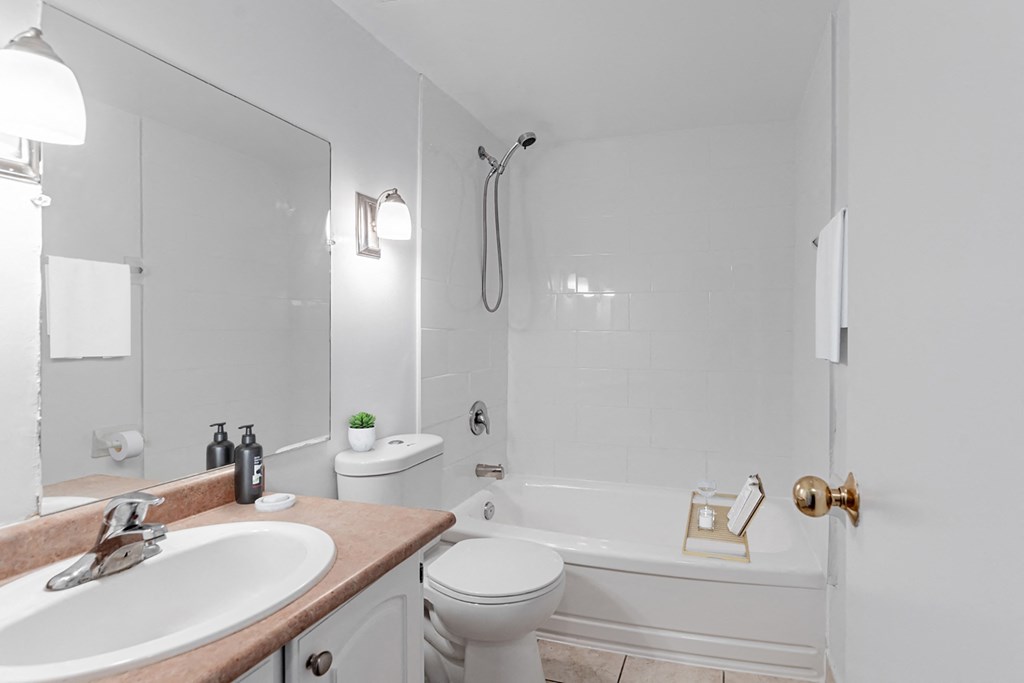 A white bathroom with a sink, toilet, and bathtub.