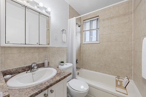 A bathroom with a sink, toilet, and bathtub.