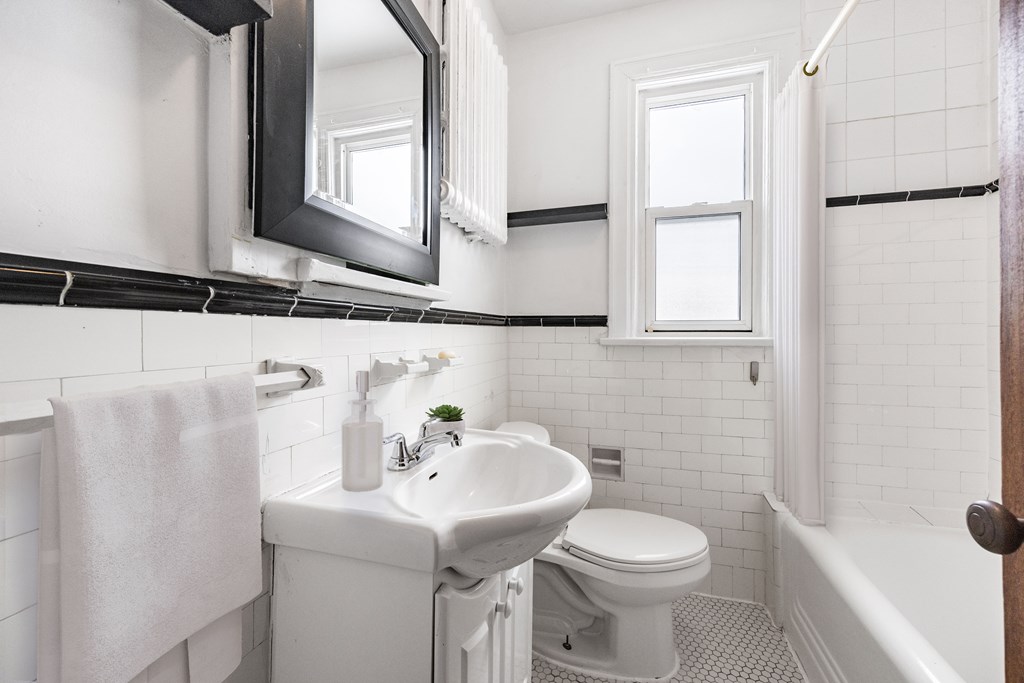 A white bathroom with a toilet, sink, and bathtub.