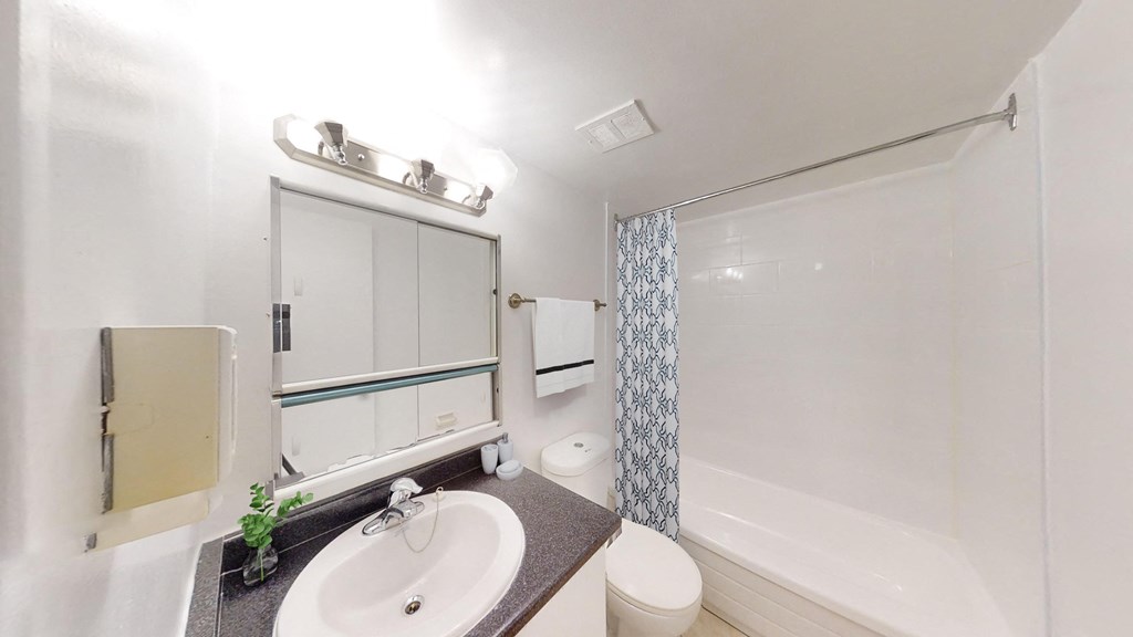 A bathroom with a sink, toilet, and bathtub.