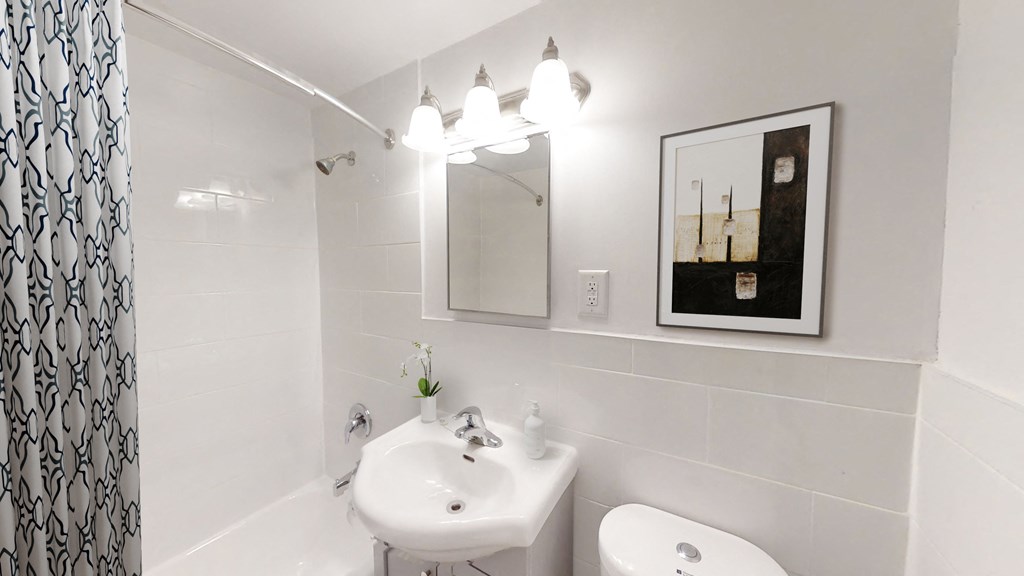 A bathroom with a white sink and toilet.