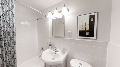 A bathroom with a white sink and toilet.