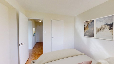 A bedroom with a bed, a rug, and two pictures on the wall.