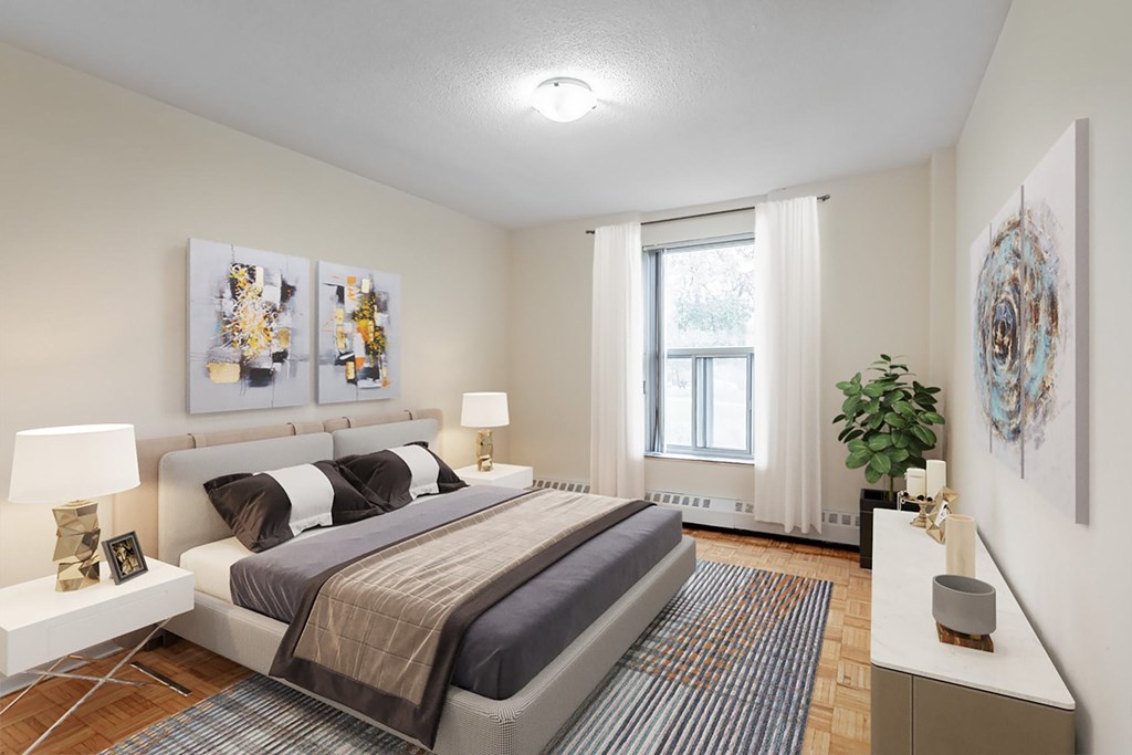 A bedroom with a large bed and two lamps.