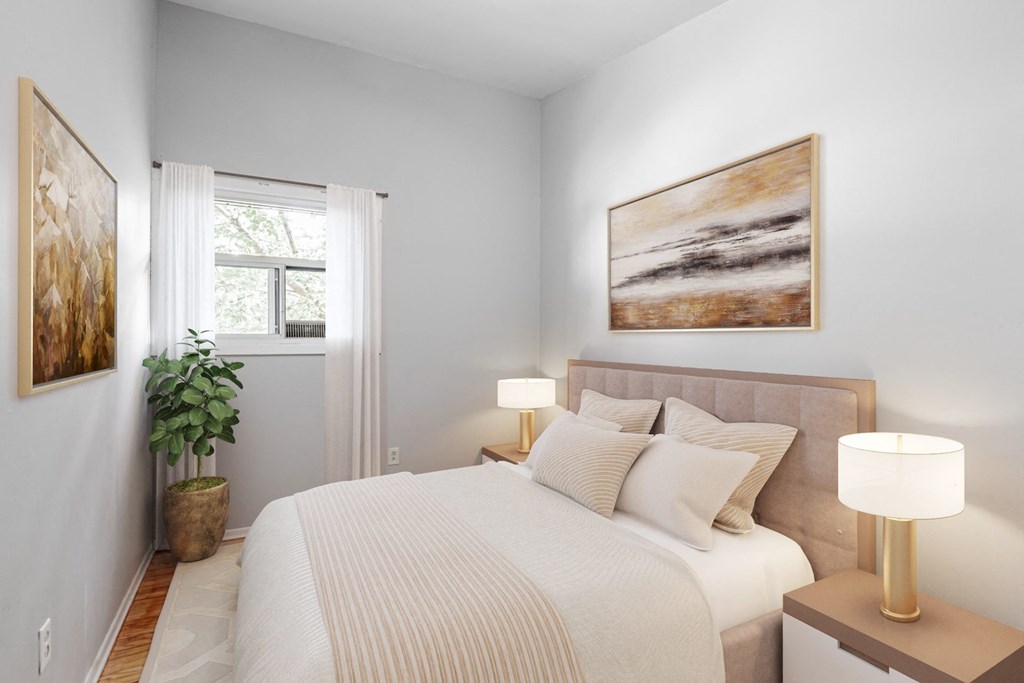 A bedroom with a large bed and two lamps.