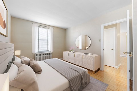 A bedroom with a large bed and a dresser with a mirror.