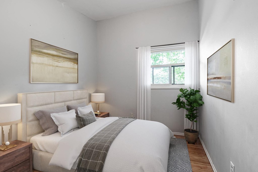 A bedroom with a large bed and a painting on the wall.