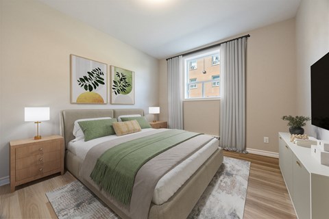A bedroom with a large bed and a green blanket.
