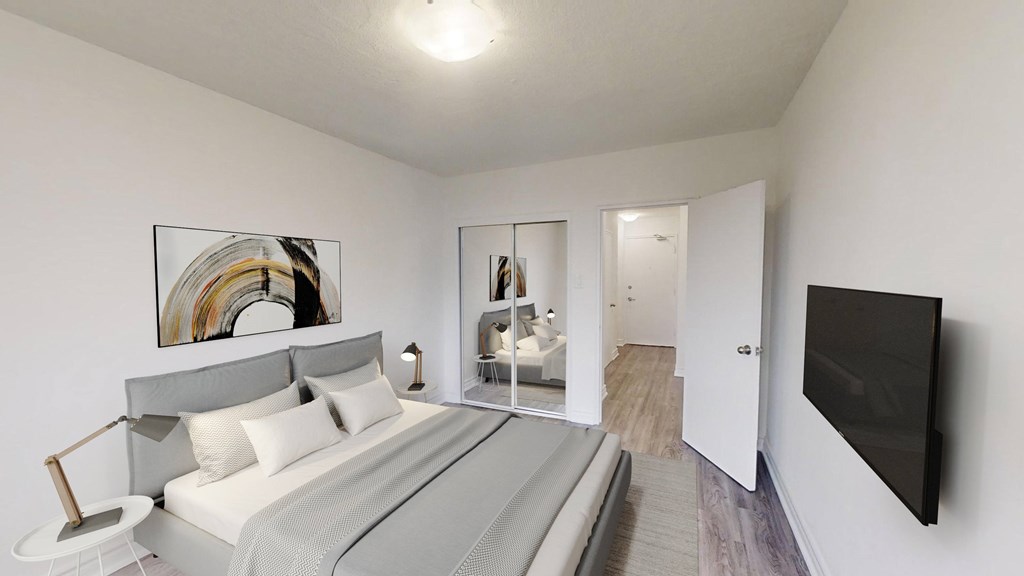 A bedroom with a bed, a lamp, a painting, and a television.