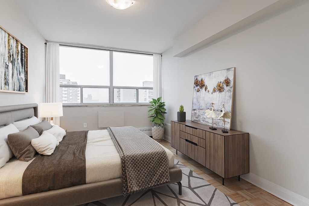 A bedroom with a large bed and a wooden cabinet.
