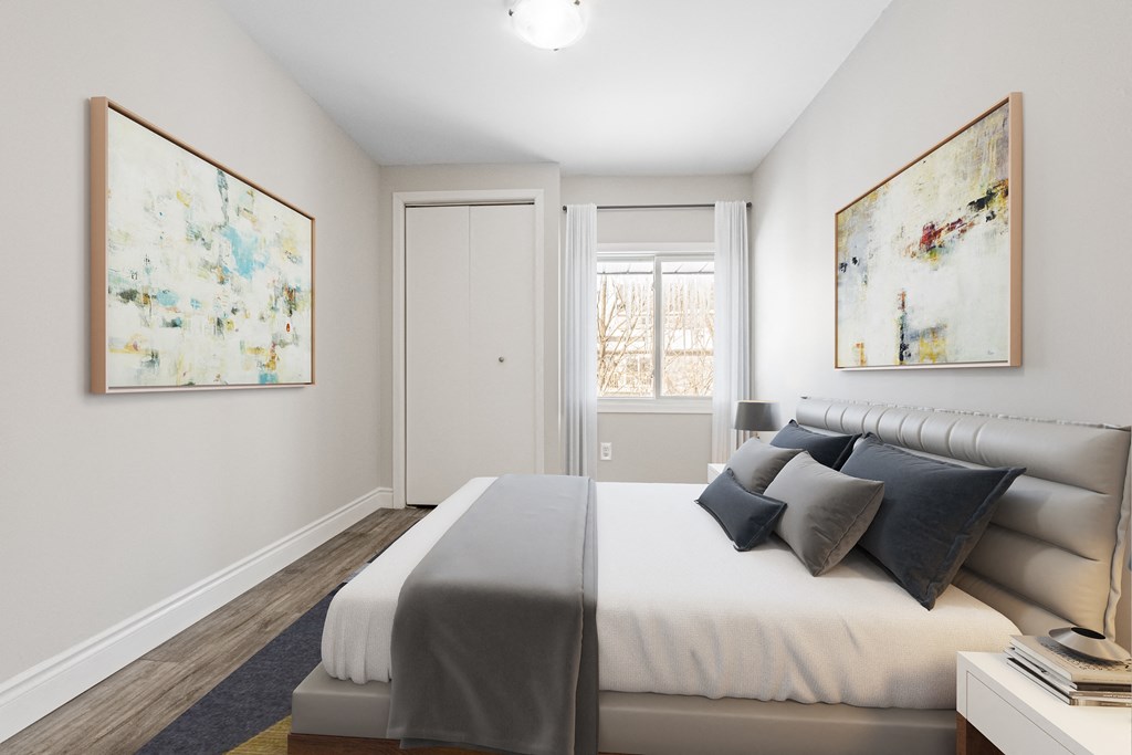 A bedroom with a bed, nightstand, and two paintings on the wall.