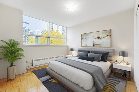 A bedroom with a large bed and a painting on the wall.