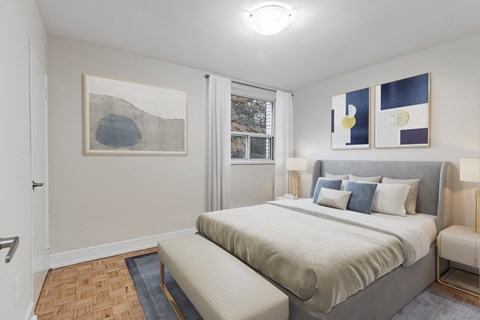 A bedroom with a large bed and a painting on the wall.