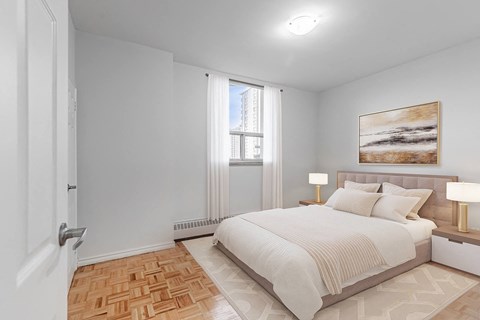 A bedroom with a large bed and a painting on the wall.