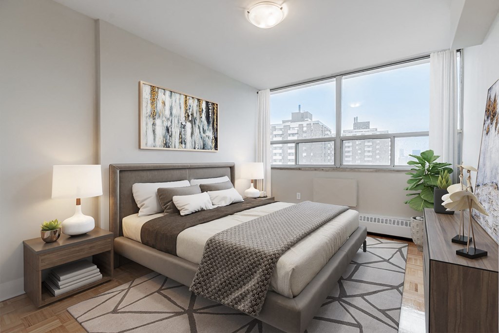 A bedroom with a large bed and a view of the city.