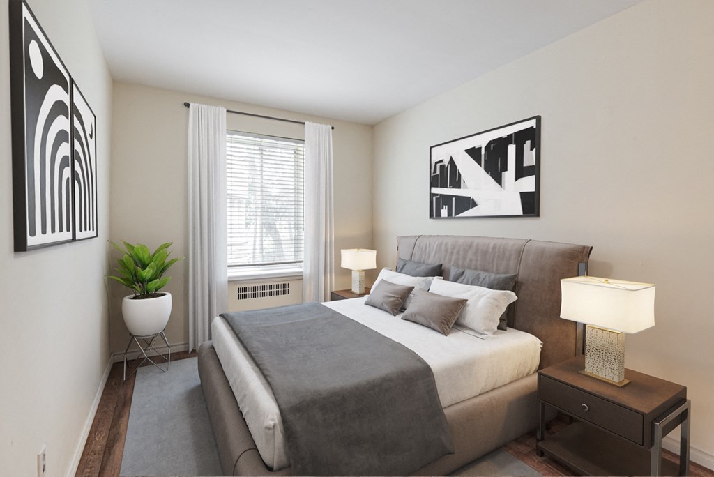 A bedroom with a bed, nightstand, and two wall art pieces.