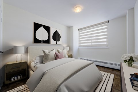 A bedroom with a large bed and two leaf-shaped pictures on the wall.