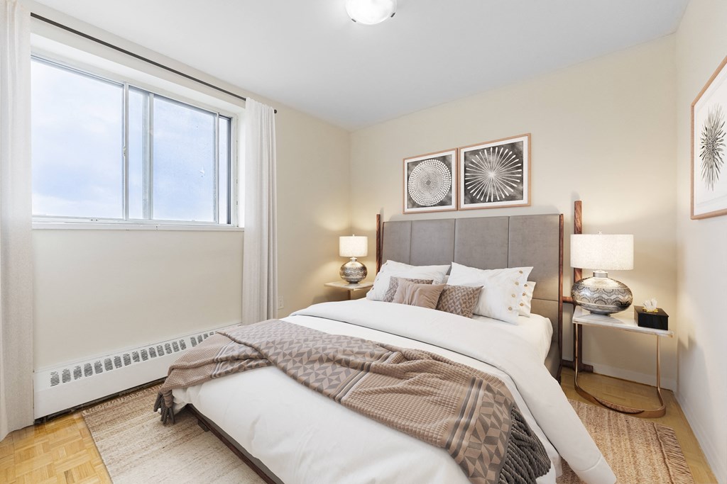 A bedroom with a large bed and a window.