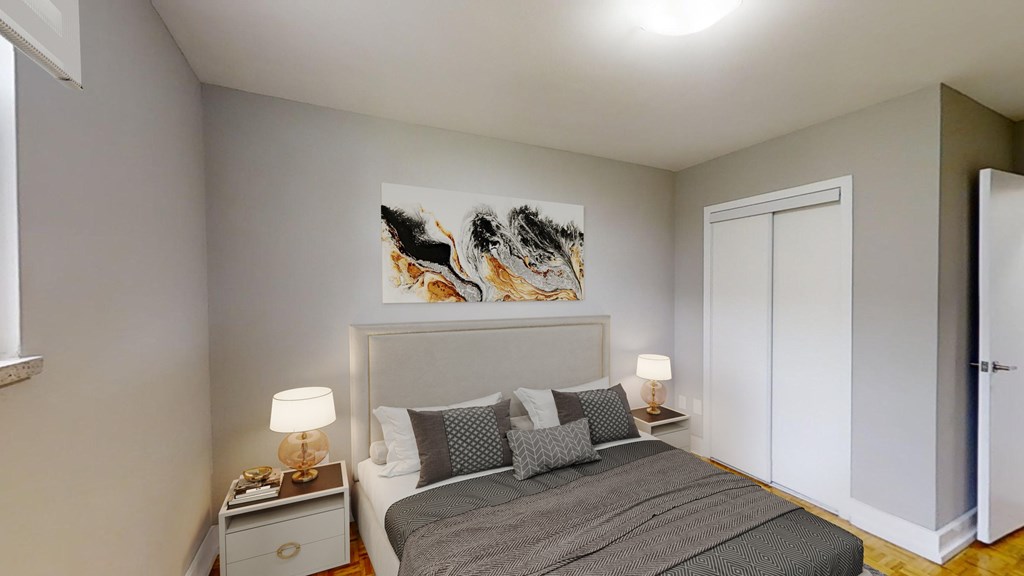 A bedroom with a large bed and a painting on the wall.