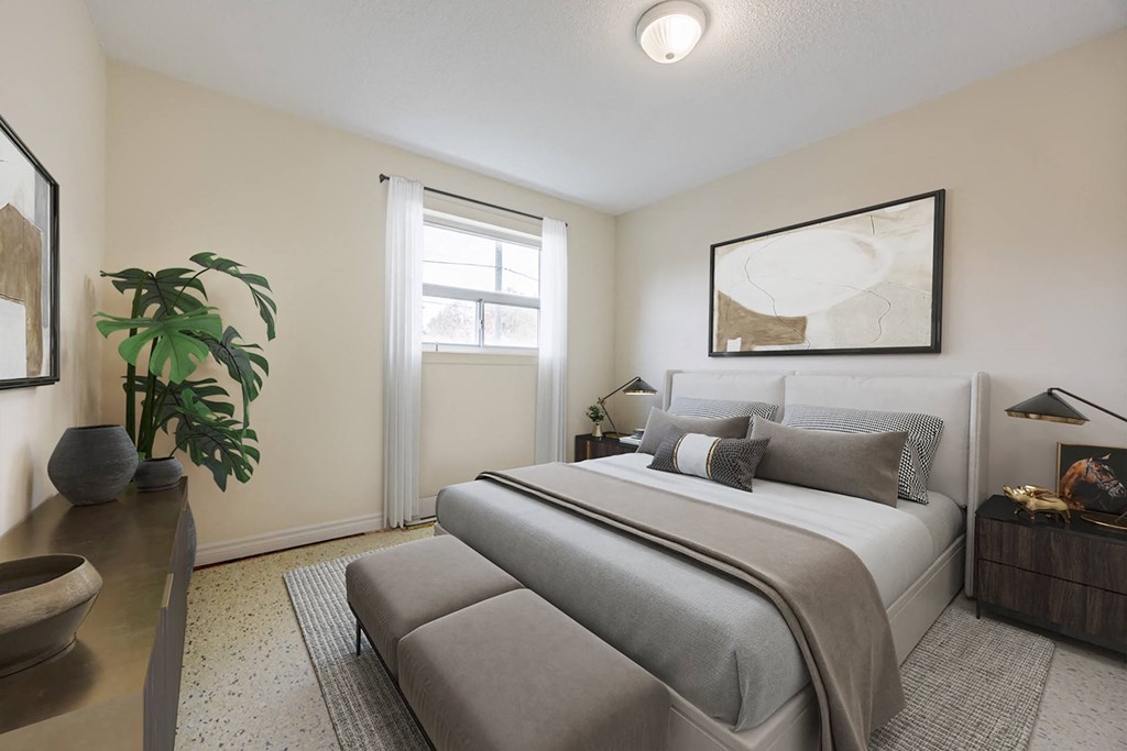 A bedroom with a large bed and a plant on the table.