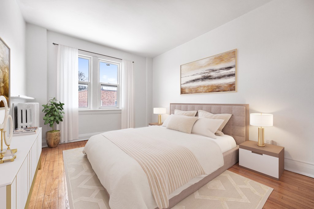 A bedroom with a large bed, a nightstand with a lamp, and a painting on the wall.