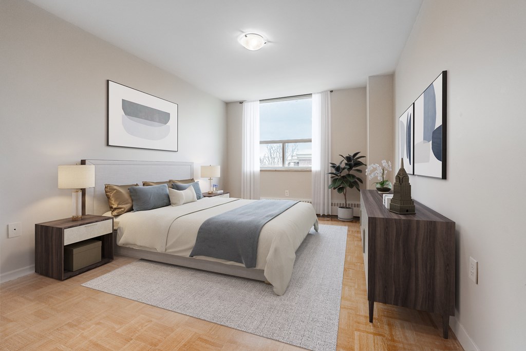 A bedroom with a large bed and a nightstand with a lamp.