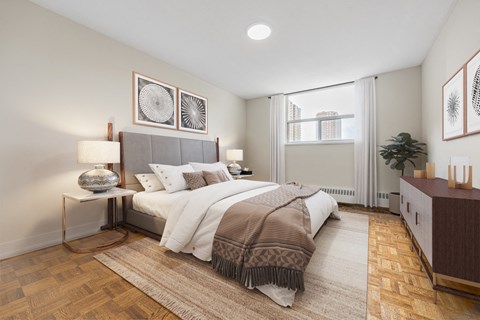 A bedroom with a large bed and a wooden floor.