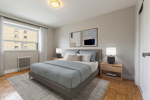 A bedroom with a large bed and a window with blinds.