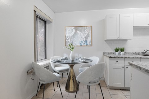 A dining area with a round table and chairs.