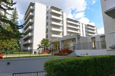 A white building with balconies and a black railing.