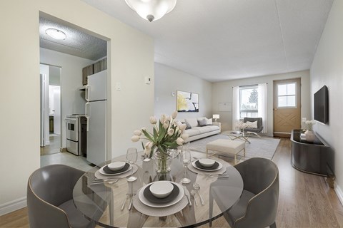 A modern dining room with a glass table and chairs.