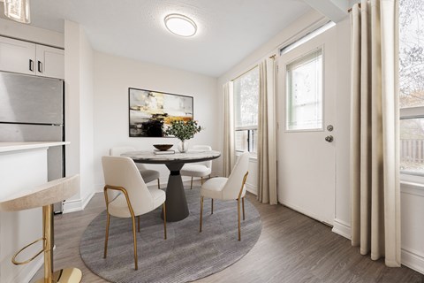 A dining room with a round table and chairs.