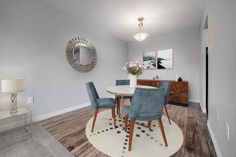 A dining room with a round table and chairs.