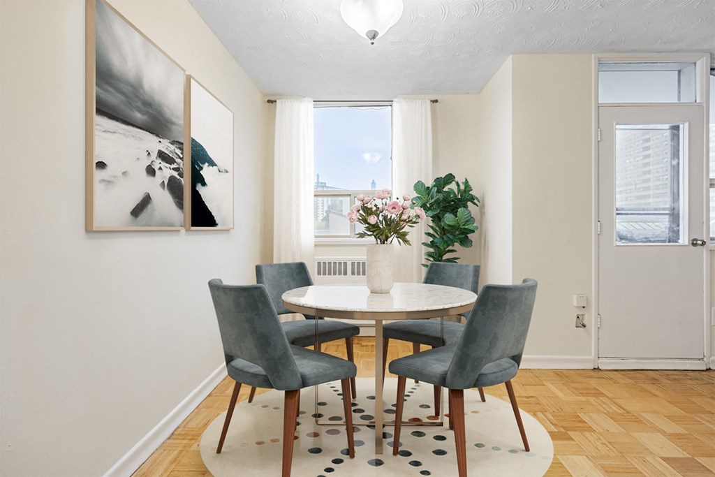 A dining room with a table and chairs.