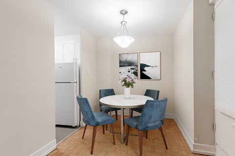 A dining room with a white table and blue chairs.