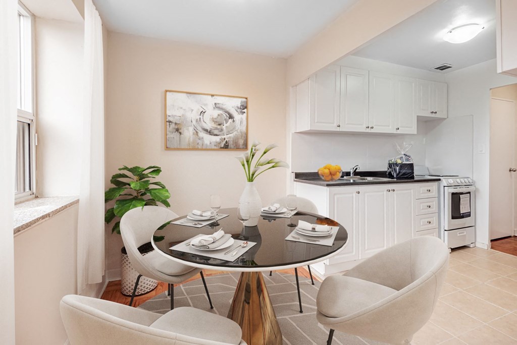 A dining room with a table set for two and a plant on the table.