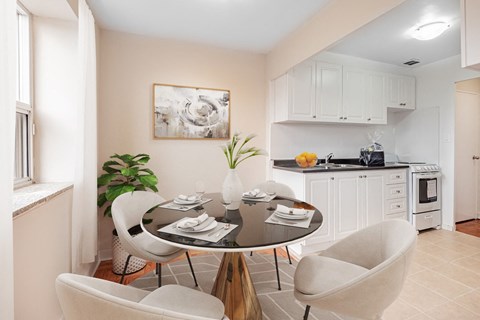 A dining room with a table set for two and a plant on the table.
