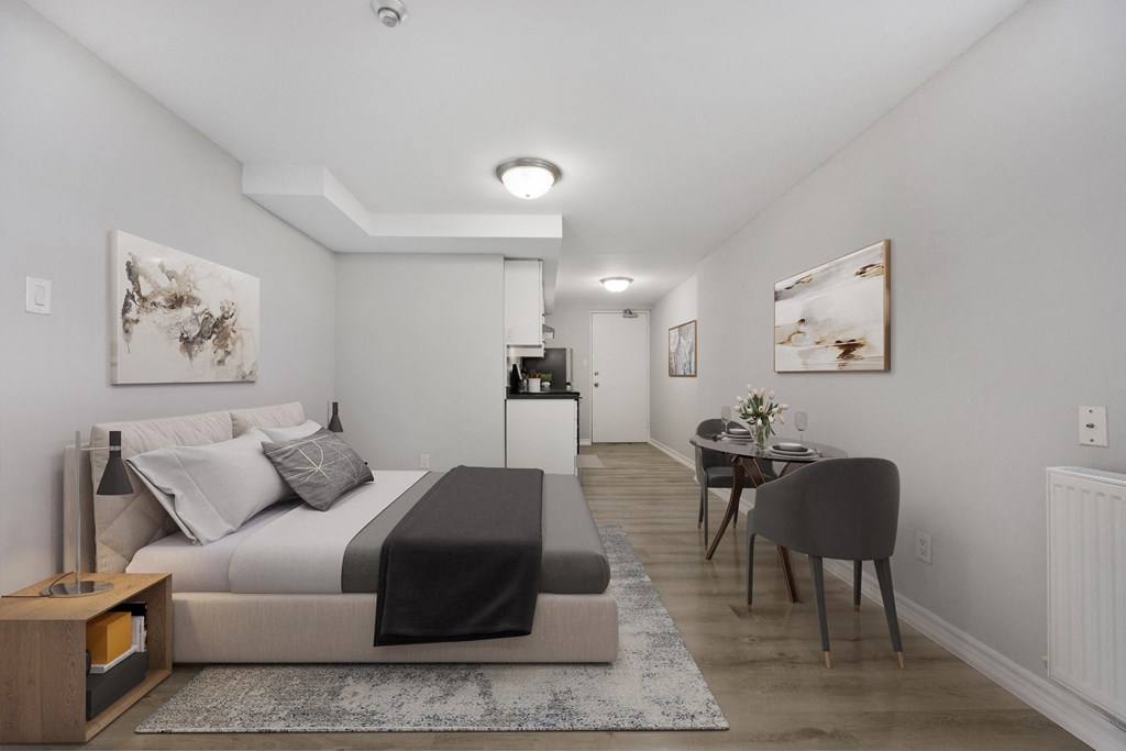 A bedroom with a bed, a chair, and a table.